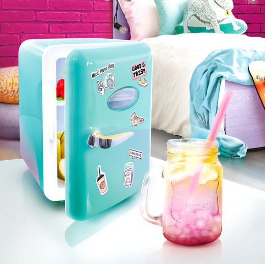 A small refrigerator with a glass of liquid next to itDescription automatically generated