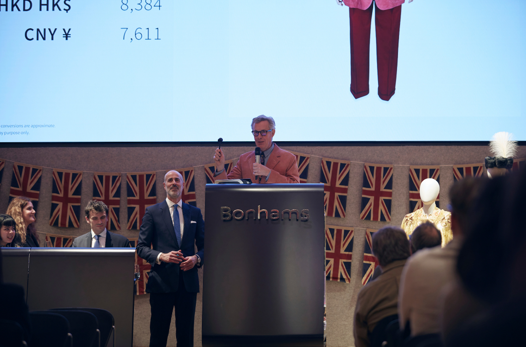 A person standing at a podium with a large screenDescription automatically generated