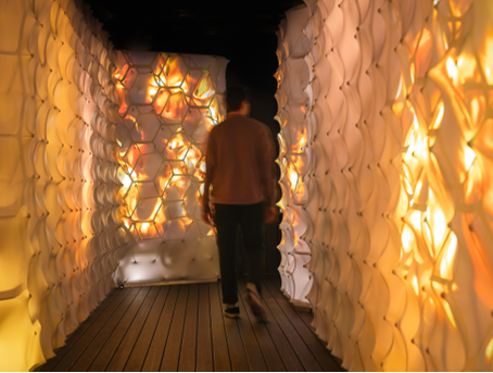 A person walking in a tunnel with lightsDescription automatically generated