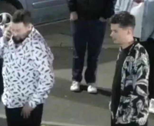 Two men, one in a white patterned shirt and the other in a black patterned shirt