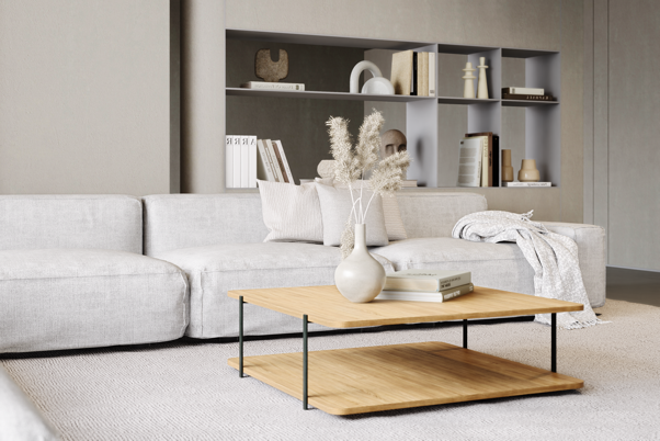 A white couch with a white vase and a wood coffee tableDescription automatically generated