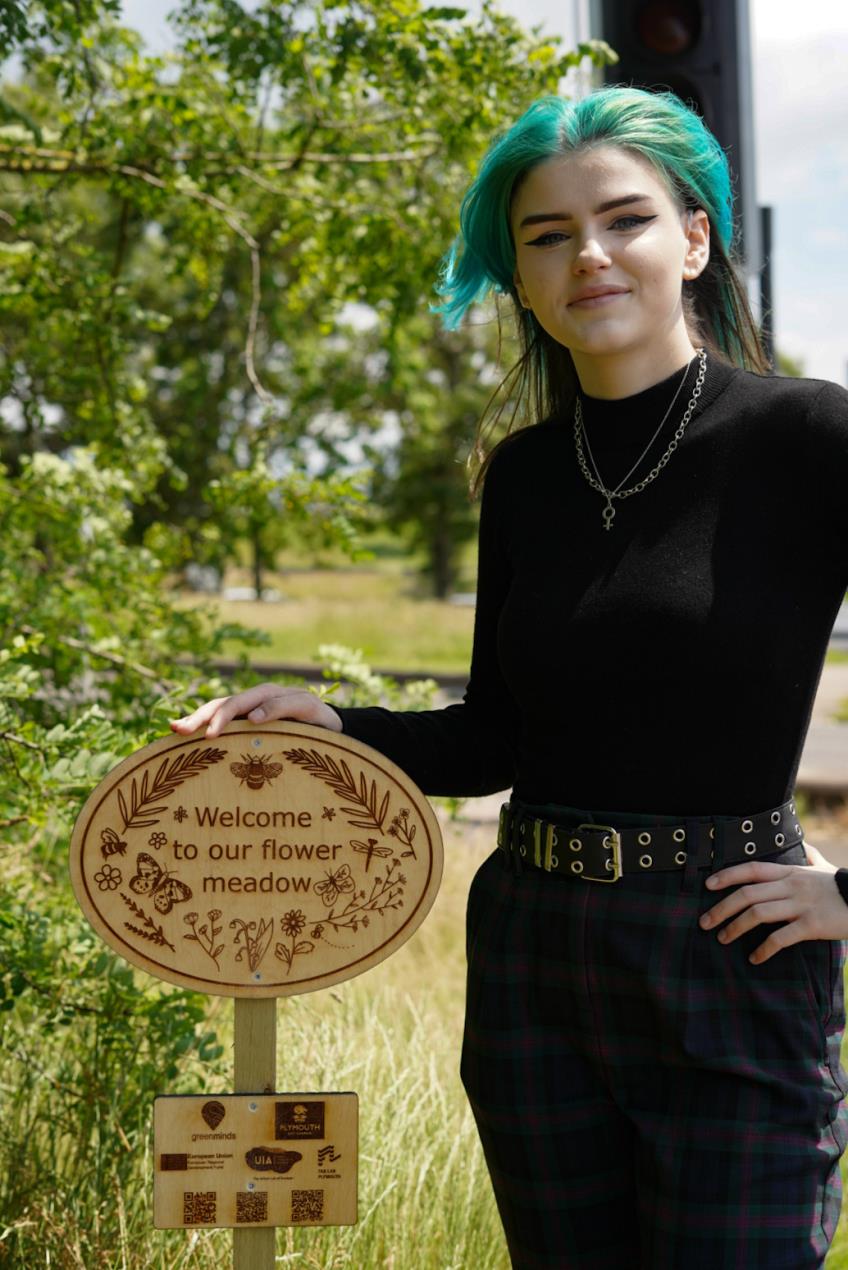 Lauren Williams with their wildflower meadow sign_Image Credit_Paul Williams