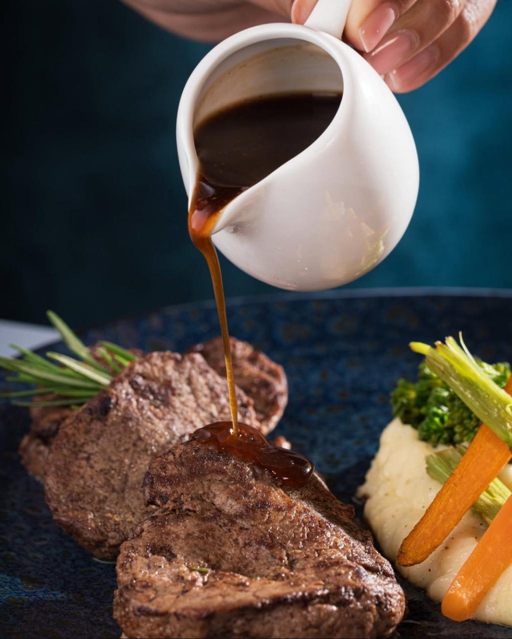 A person pouring gravy on meatAI-generated content may be incorrect.