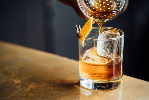 Old Fashioned Cocktail Being Poured Into a Glass