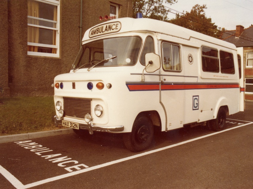 An ambulance parked in front of a buildingDescription automatically generated