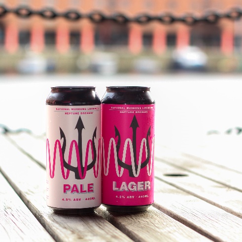 Two cans of beer on a tableDescription automatically generated