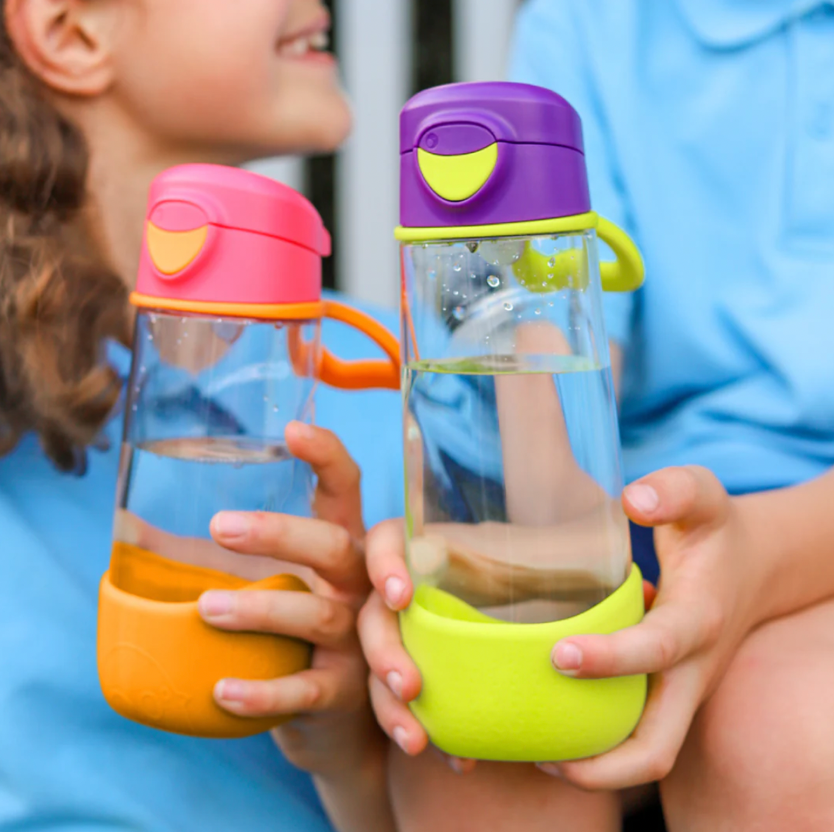 Two girls holding bottles with waterDescription automatically generated