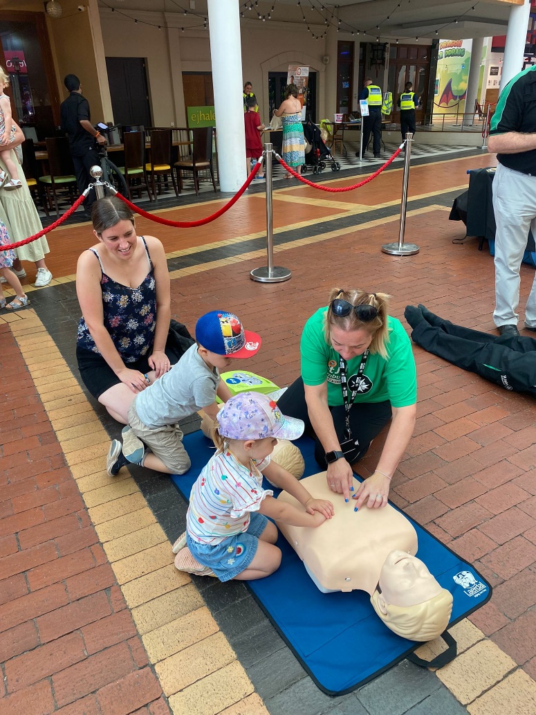 A group of people practicing cpr on a mannequinDescription automatically generated