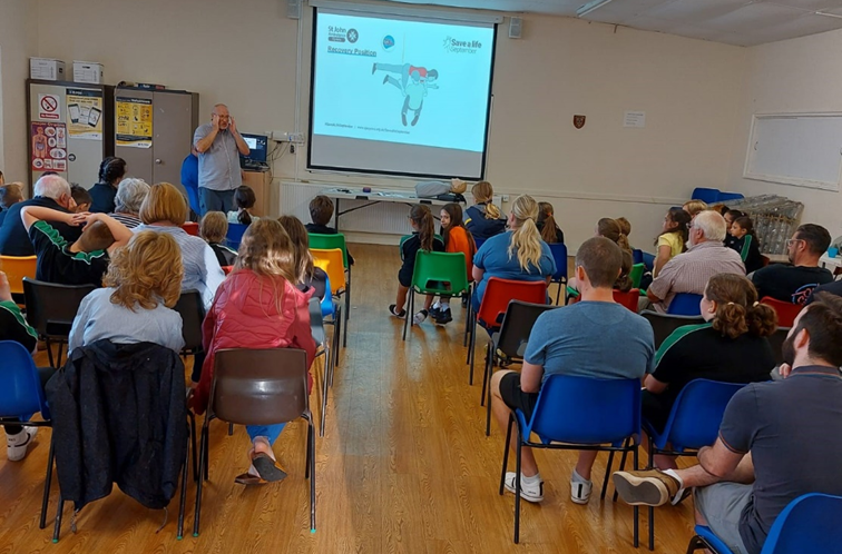 a group of people watching a cpr demonstration