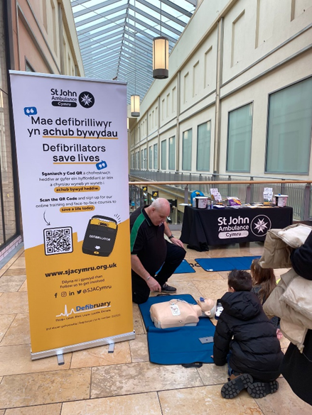 st john ambulance cymru volunteer teaching how to use an aed