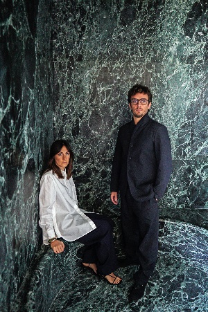 A person and person sitting on a marble staircaseAI-generated content may be incorrect.