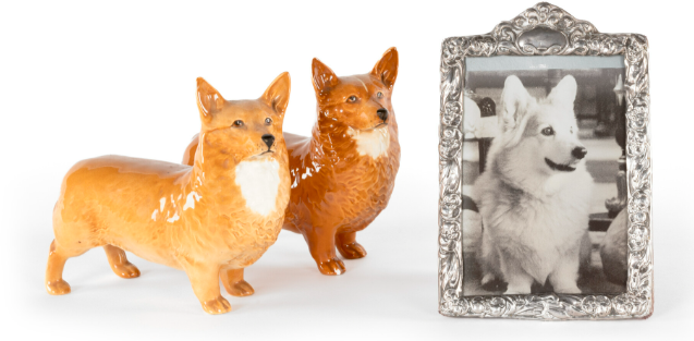 A couple of dogs figurines next to a picture frameDescription automatically generated