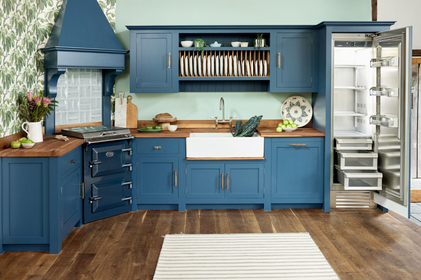 A kitchen with blue cabinets and a white rugDescription automatically generated