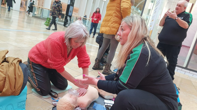 a member of the public learning how to use a defibrillator