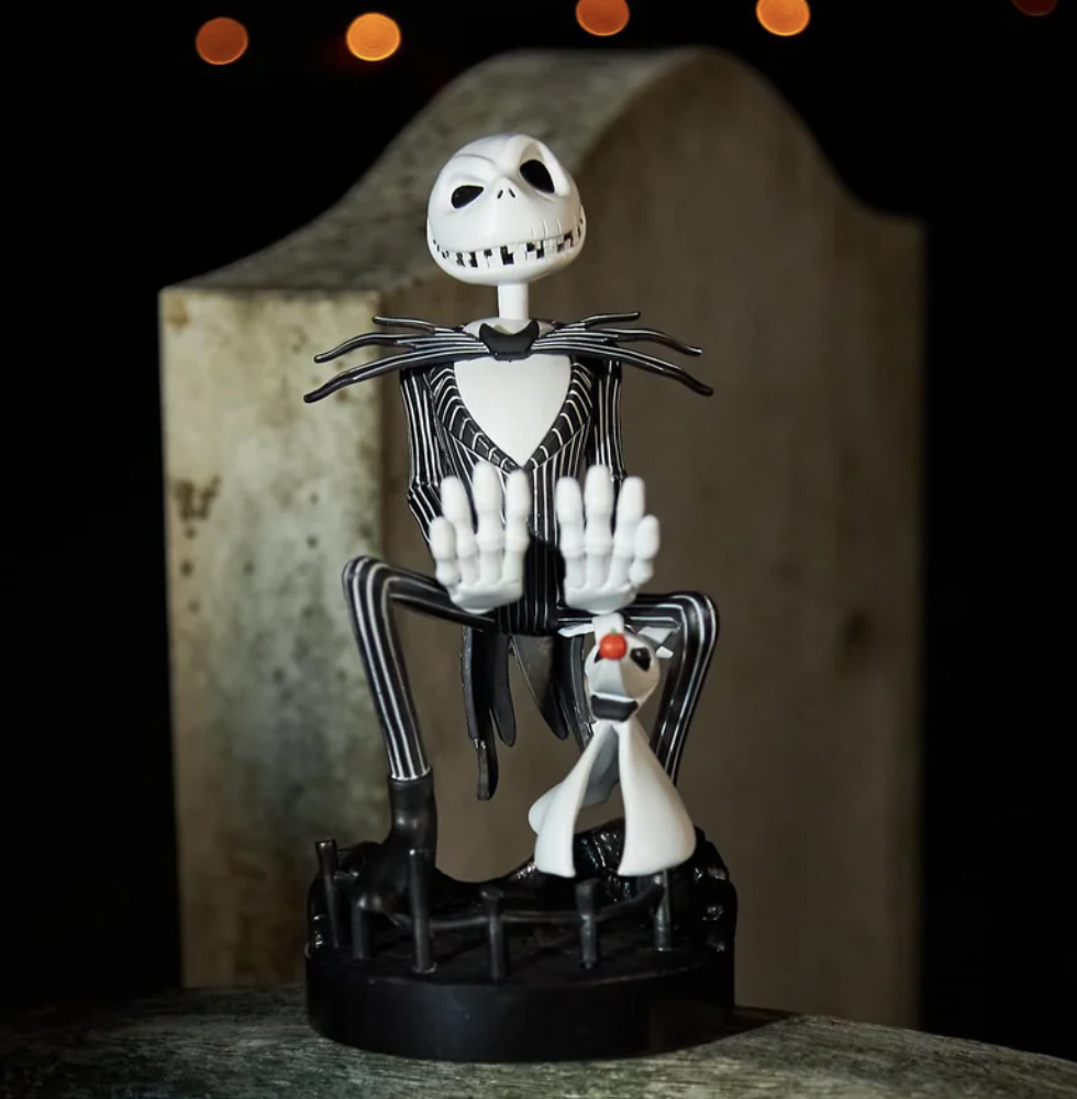 A toy figure of a skeleton sitting on a black and white objectDescription automatically generated