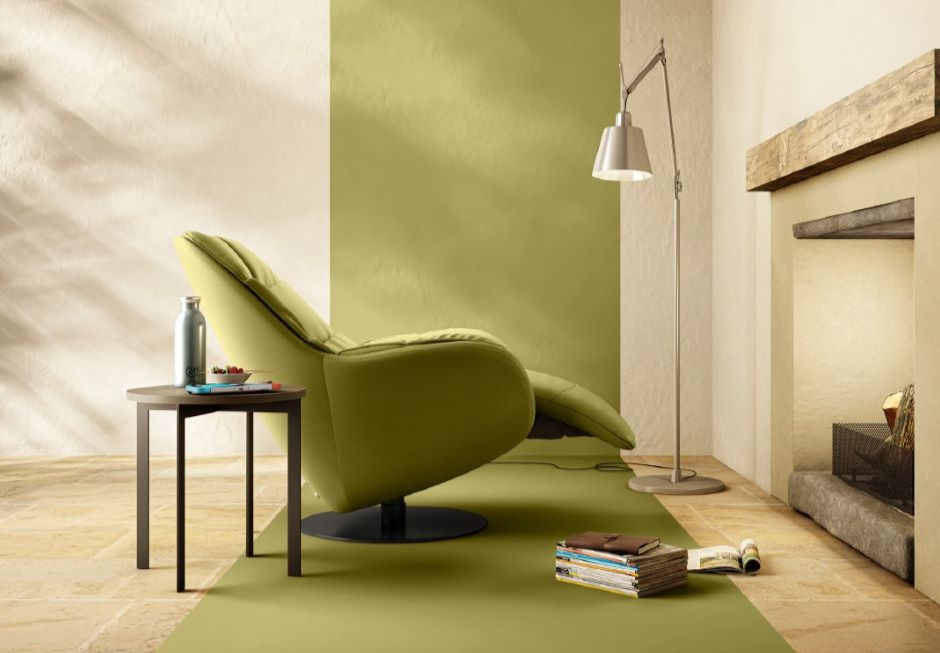 A green chair and a table in a roomDescription automatically generated