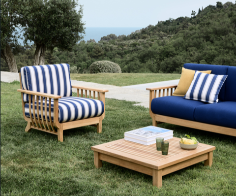 A blue and white striped chairs on grass with a table and a coffee tableAI-generated content may be incorrect.
