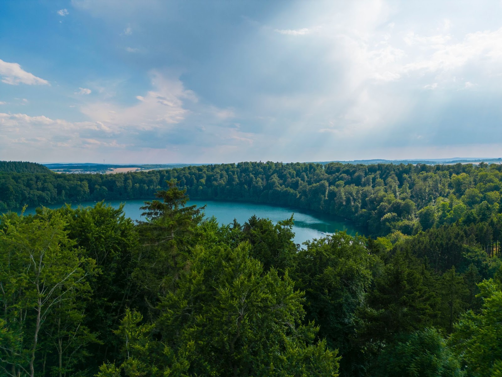 A lake surrounded by treesDescription automatically generated