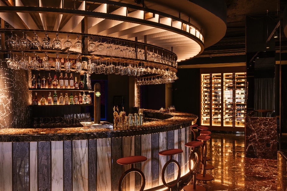 A bar with wine glasses and shelvesAI-generated content may be incorrect.