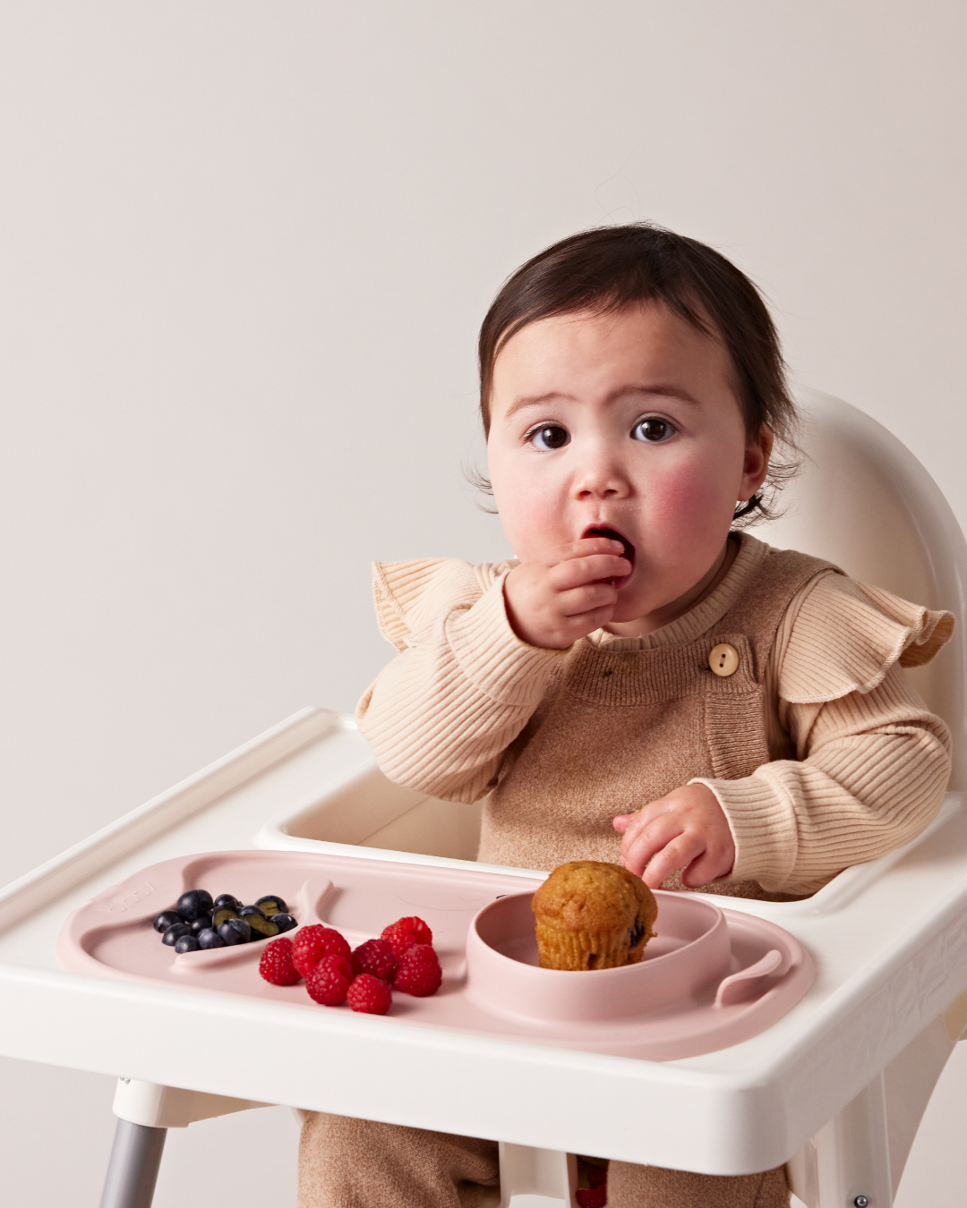 A baby eating a muffinAI-generated content may be incorrect.