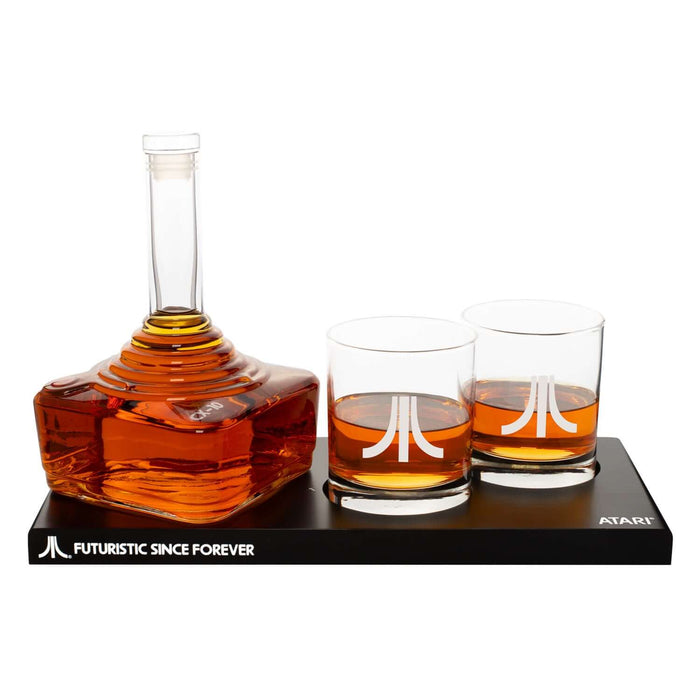 Atari decanter set with joystick-shaped decanter, 2 emblem glasses on tray with "Futuristic Since Forever" slogan.