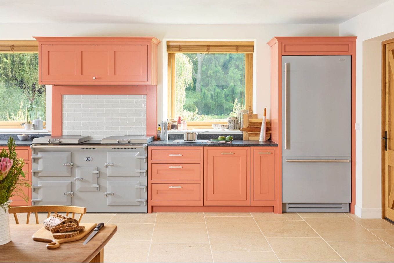 A kitchen with orange cabinets and a windowDescription automatically generated