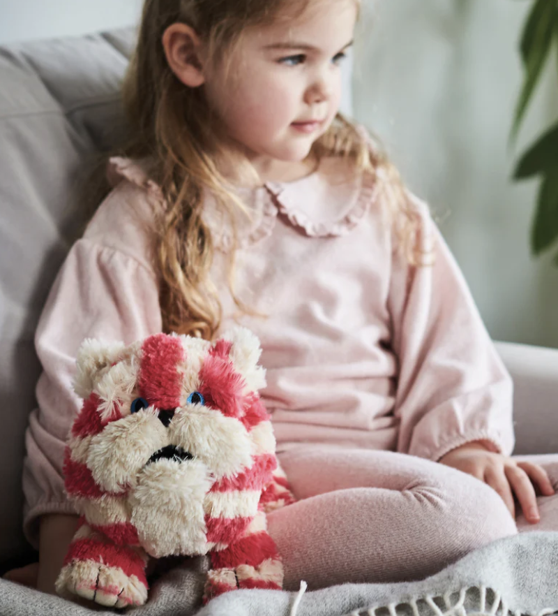 A child sitting on a couch with a stuffed animalDescription automatically generated