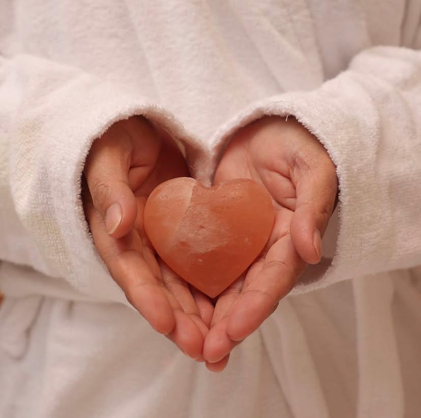 A person holding a heart shaped objectDescription automatically generated