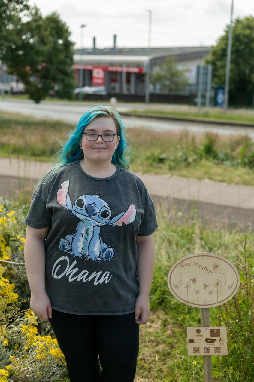 Bethan Price-Nicholls with their wildflower meadow sign_Image Credit_Ray Goodwin