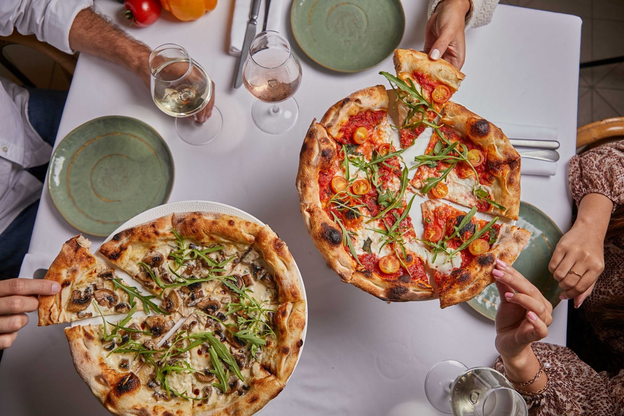 A group of people holding pizzasAI-generated content may be incorrect.