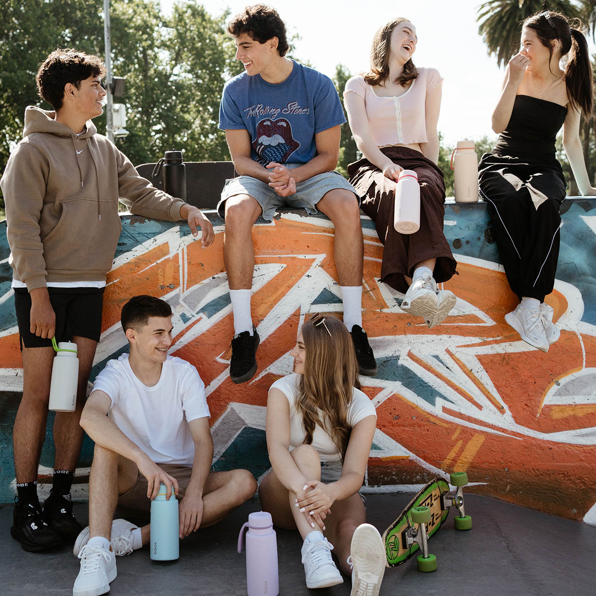 A group of people sitting on a wallDescription automatically generated