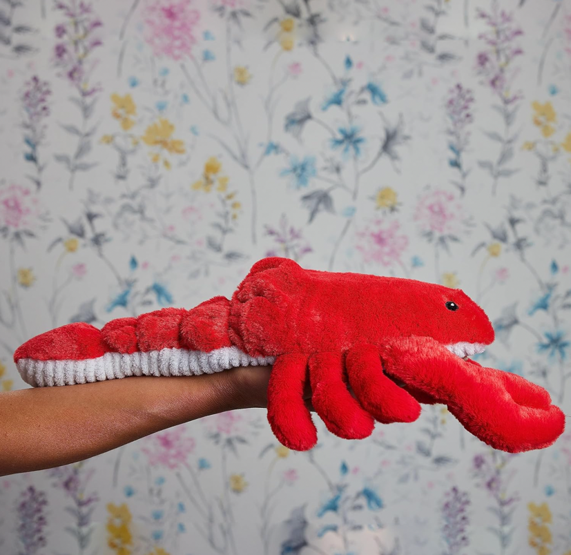 A hand holding a stuffed lobster toyDescription automatically generated